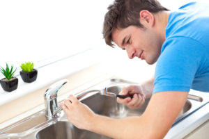 Manual man repairing a kitchen sink at home